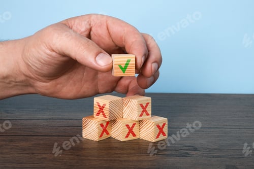 Preview: Woman putting wooden cube with checkmark onto others with cross marks on table, closeup. Following r