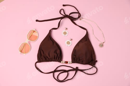 Preview: Bikini top and beach accessories on pink background, flat lay