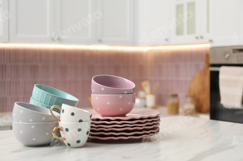 Preview: Different clean dishware on white table in kitchen. Space for text