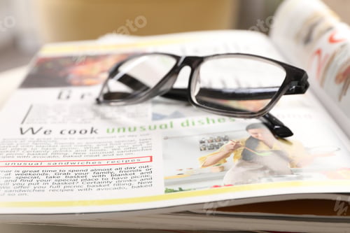 Preview: Stack of magazines and glasses on white table indoors, closeup