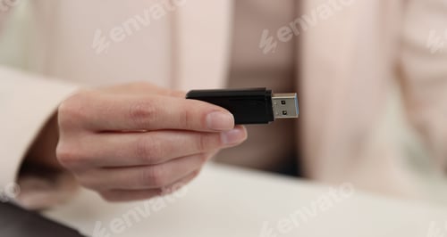 Preview: Woman with USB flash drive at desk, closeup