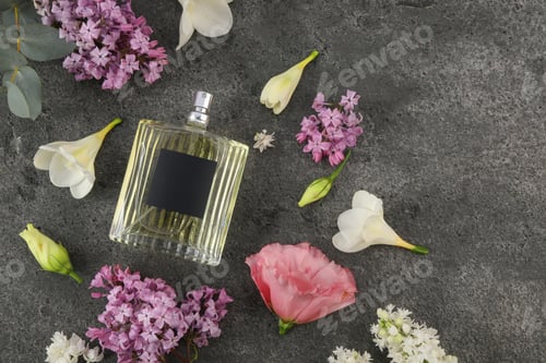 Vista previa: Bottle of luxury perfume and floral decor on dark grey table, flat lay. Space for text