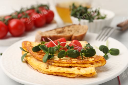 Preview: Tasty breakfast with omelette, microgreens, tomatoes, bread and tea on table, closeup