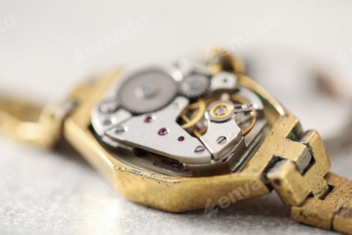 Preview: Mechanism of vintage wrist watch on grey table, closeup