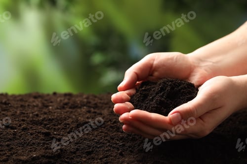 Preview: Woman with fresh soil on blurred background, closeup