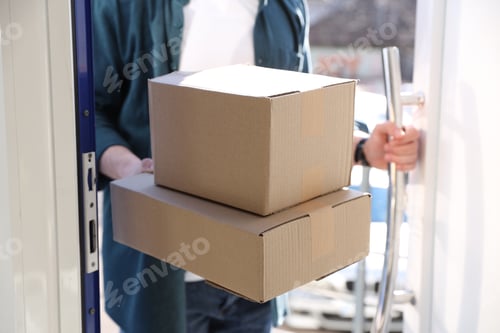 Preview: Parcel delivery. Courier with cardboard boxes indoors, closeup
