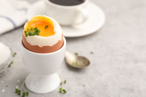 Preview: Tasty breakfast with soft boiled egg, microgreens, salt and coffee on grey table, closeup. Space for