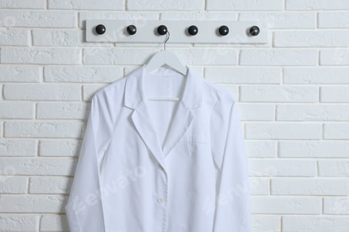 Preview: Medical worker uniform hanging on white brick wall