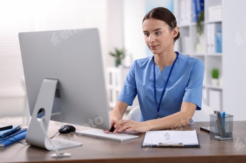 Preview: Medical assistant working on computer at desk in clinic