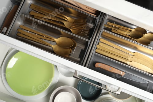Preview: Ceramic dishware and cutlery in drawers indoors, top view