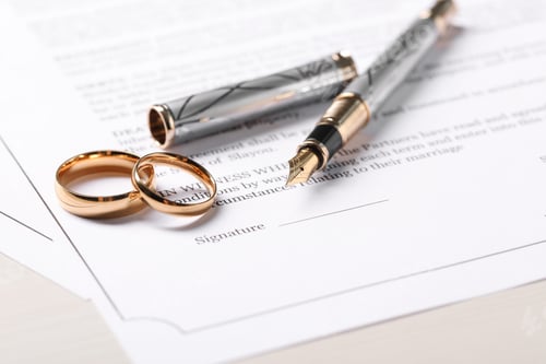 Preview: Marriage contracts, gold rings and pen on light wooden table, closeup