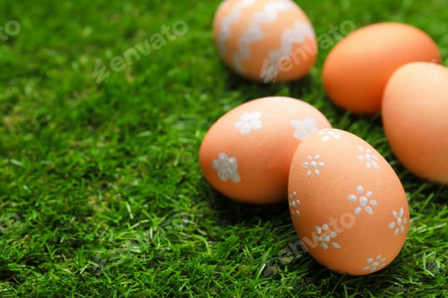 Preview: Beautiful decorated Easter eggs on green grass outdoors, closeup. Space for text