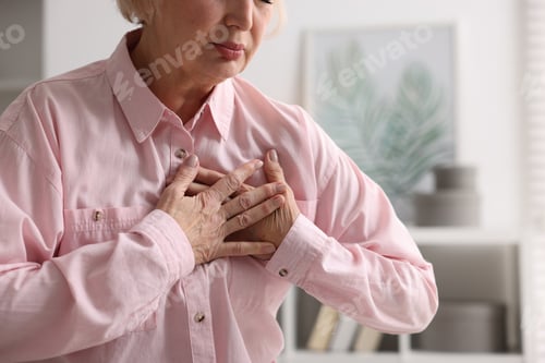 Preview: Heart attack. Senior woman suffering from pain in chest indoors, closeup