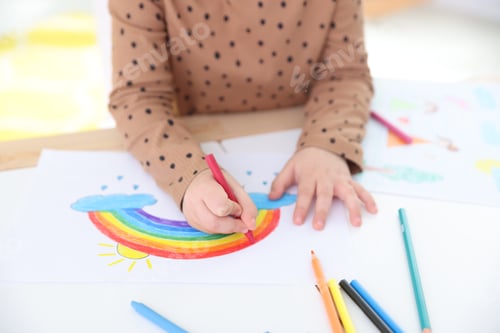 Preview: Little girl drawing with pencil at table indoors, closeup