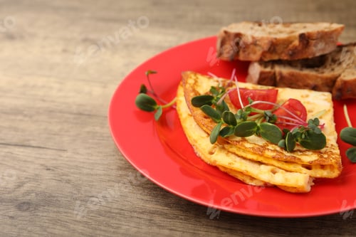 Preview: Tasty breakfast with omelette, microgreens, tomatoes and bread on wooden table, closeup. Space for t