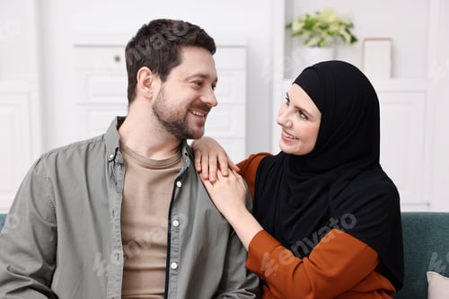 Preview: Portrait of happy muslim couple on sofa at home