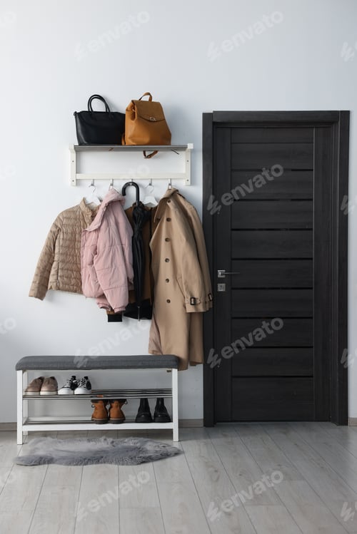Preview: Shoe storage bench with different footwear and coats in hallway. Interior design