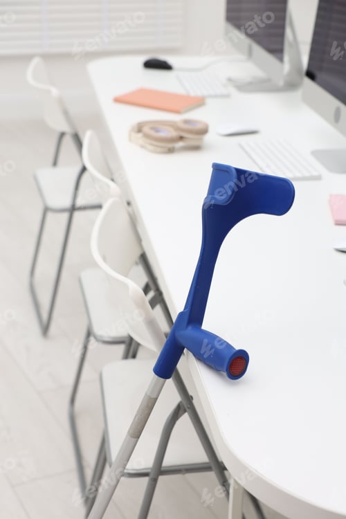 Preview: Elbow crutch near white table at workplace indoors, closeup. Mobility aid
