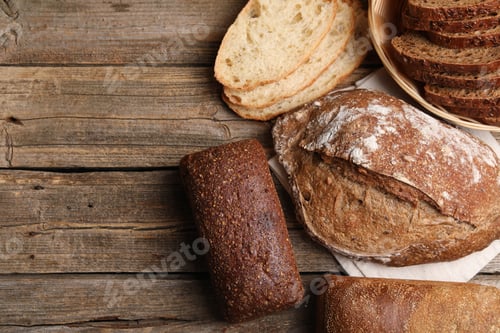 Preview: Different types of bread on wooden table, flat lay. Space for text