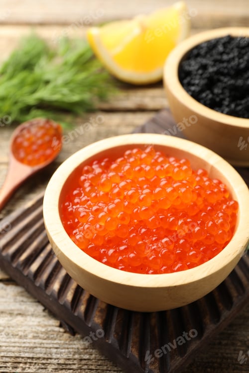 Preview: Delicious red and black caviar with dill, lemon slices on wooden table, closeup