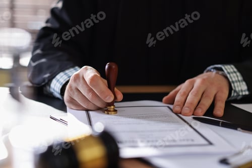 Preview: Judge stamping document at table indoors, closeup