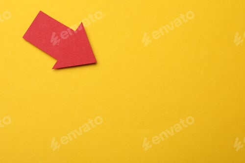 Preview: Red paper arrow on yellow background, top view. Space for text