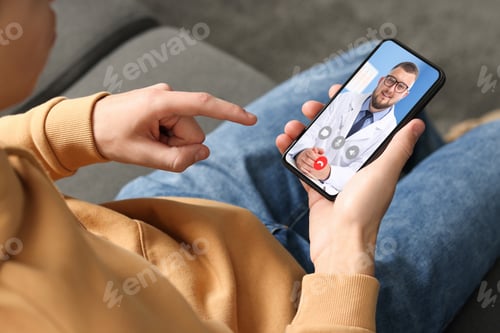 Preview: Telemedicine. Man having online consultation with doctor via mobile phone at home, closeup