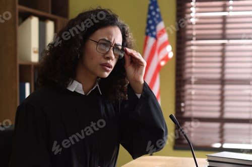Preview: Judge with documents at wooden desk indoors