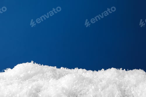 Preview: Pile of snow on surface against blue background, closeup. Space for text