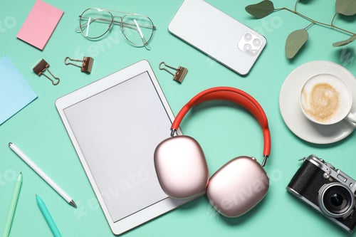 Preview: Headphones, smartphone, tablet, coffee, glasses and stationery on turquoise background, flat lay