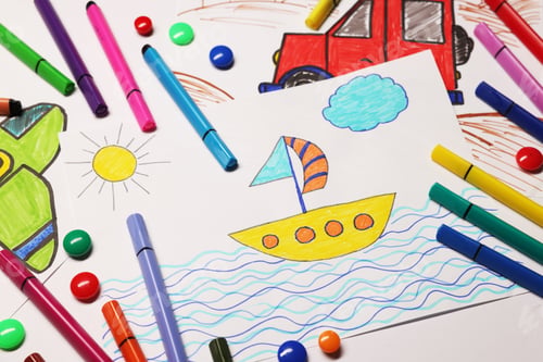Preview: Child's drawings and felt-tip pens on white background, above view