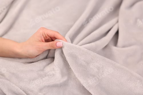 Preview: Woman touching soft light grey blanket, closeup