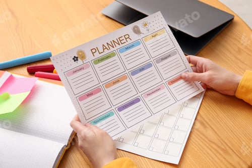 Preview: Woman using planner at wooden table, closeup