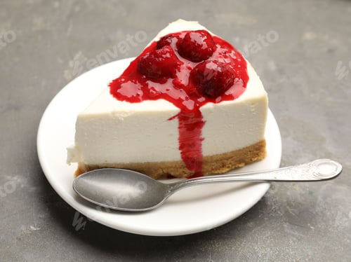 Preview: Piece of delicious cheesecake with raspberry preserves served on gray textured table, closeup