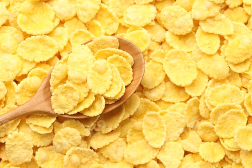 Preview: Tasty corn flakes and wooden spoon, top view. Space for text