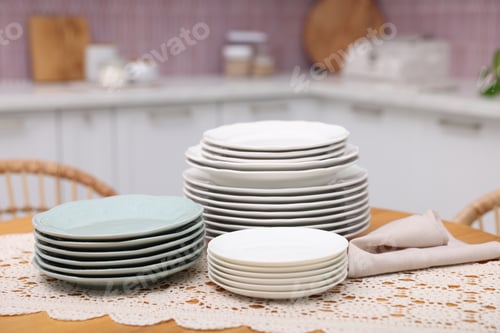 Preview: Set of clean plates on wooden table in kitchen, closeup