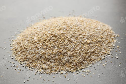 Preview: Pile of oat bran on grey table, closeup