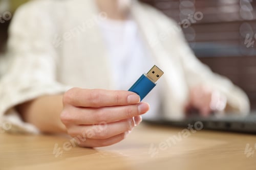 Preview: Woman with USB flash drive working on laptop at desk, closeup