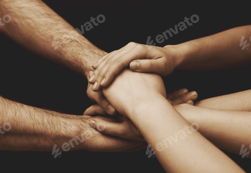 Preview: Young people putting their hands together on dark background, closeup