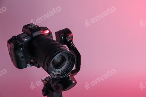 Preview: Gimbal stabilizer with camera on pink background, closeup. Space for text