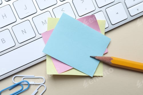 Preview: Reminder. Blank sticky notes, keyboard, paperclips and pencil on beige table, flat lay