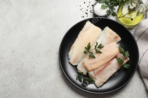 Preview: Plate with raw cod fish, parsley, oil and spices on light textured table, flat lay. Space for text