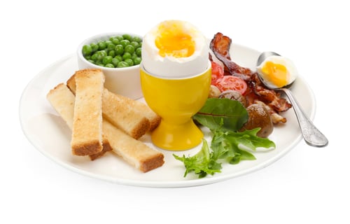 Preview: Tasty breakfast with soft boiled egg, bacon, green peas, mushrooms, tomatoes and toasted bread isola