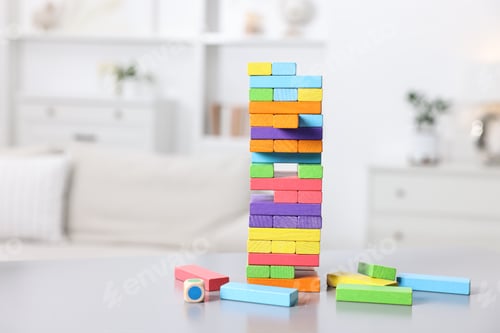 Preview: Colorful tower made of wooden blocks on white table indoors, closeup