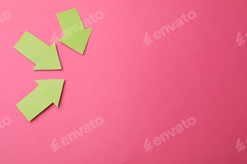 Preview: Green paper arrows on pink background, flat lay. Space for text