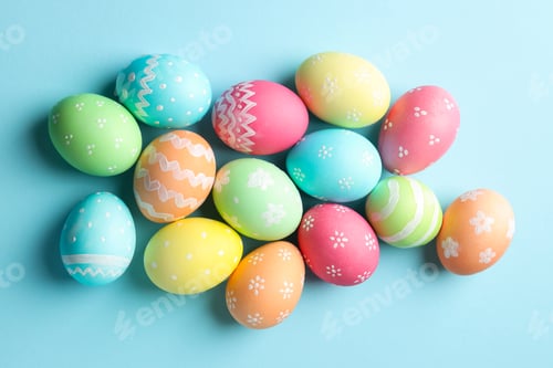 Preview: Many painted Easter eggs on light blue background, flat lay