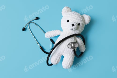 Preview: Pediatrician concept. Toy bear and stethoscope on light blue background, top view