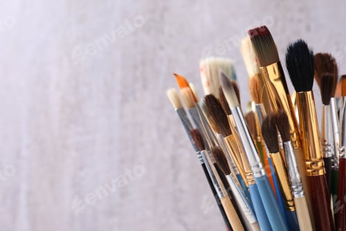 Preview: Different paint brushes on light background, closeup. Space for text