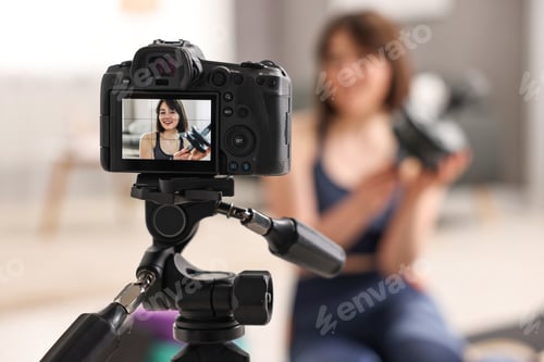 Preview: Happy sports blogger with ab roller recording fitness lesson at home, focus on camera