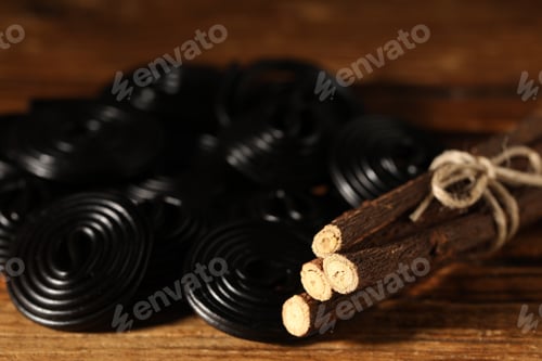 Preview: Natural licorice candies and roots on wooden table, closeup